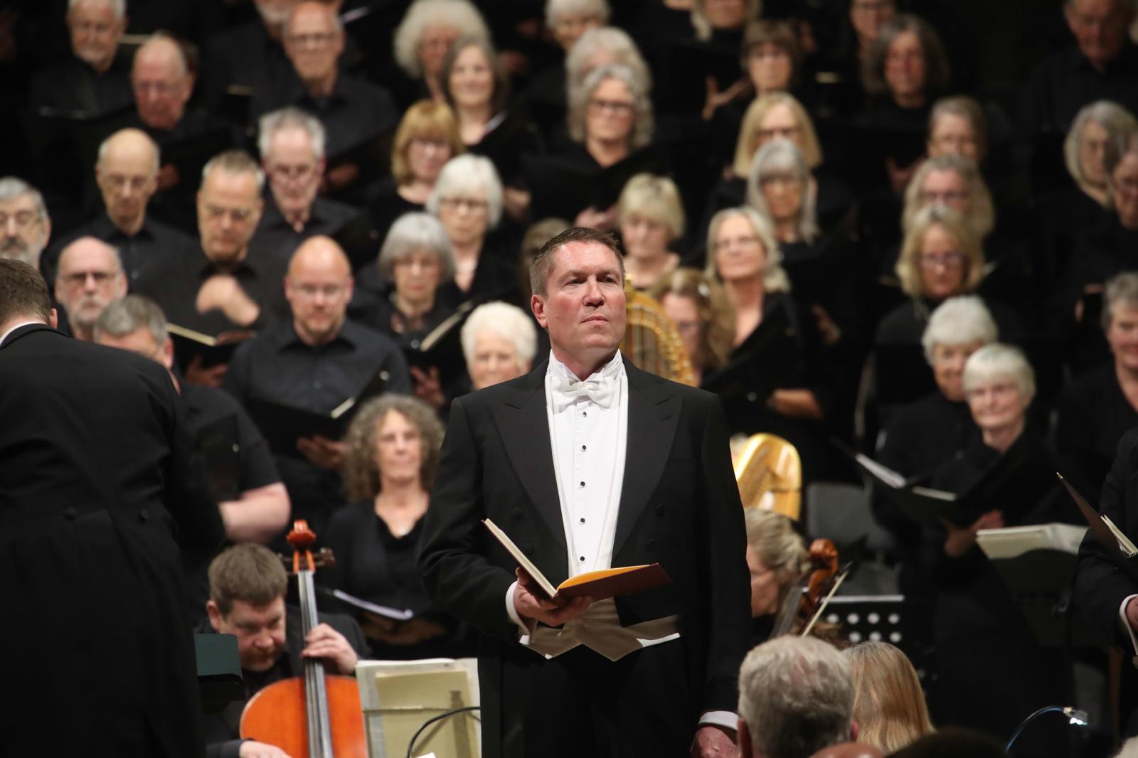 Matthew Minter performing with conductor and soloist during a concert.
